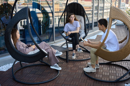Man and two women sitting on terrace of business center