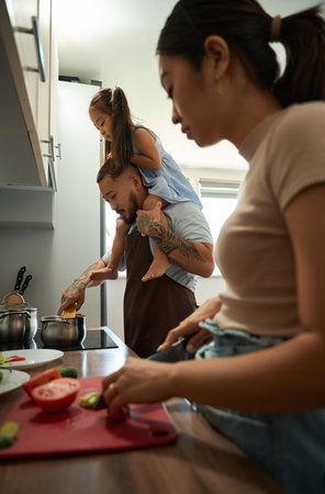 Asian family preparing dinner together in the kitchenの写真素材