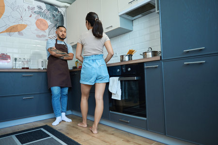 Asian man and woman talking in the kitchenの写真素材