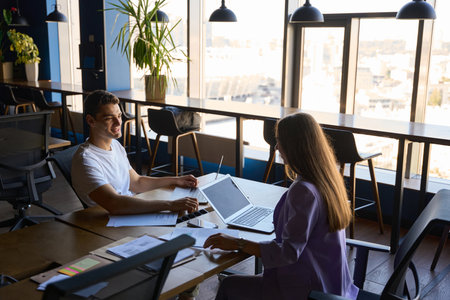 Man and woman talking at the desk in the office