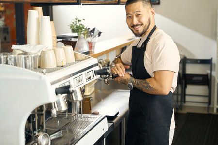 Smiling barista doing his work with joy and prideの写真素材