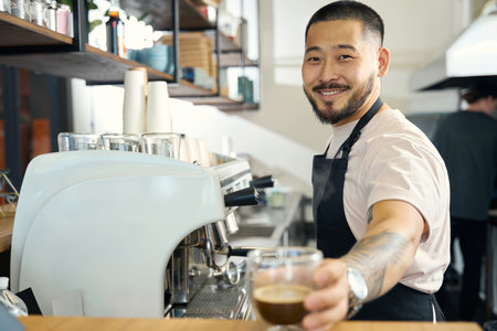 Friendly bearded coffee shop worker presenting a hot beverage