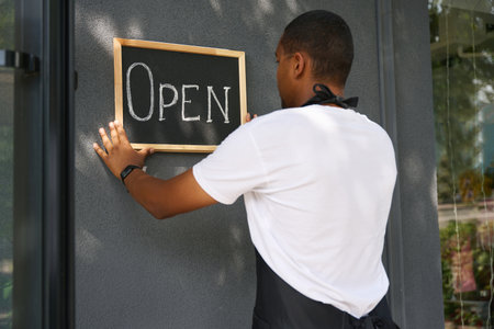 African american man hanging a sign on the wallの写真素材