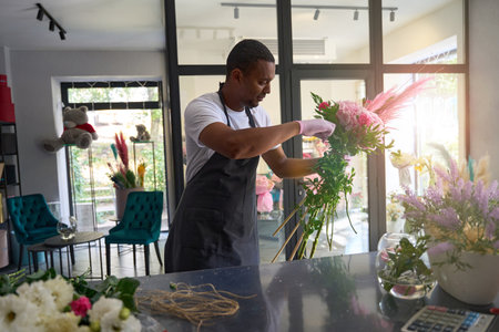 Adult male holding bouquet indoors flower shopの写真素材