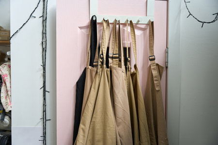 Work aprons hang on a wooden hangerの写真素材