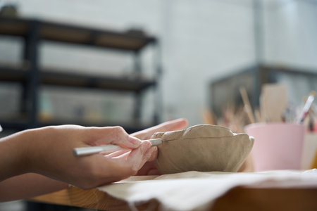 Craftswoman holds a stack and clay blank in her handsの写真素材