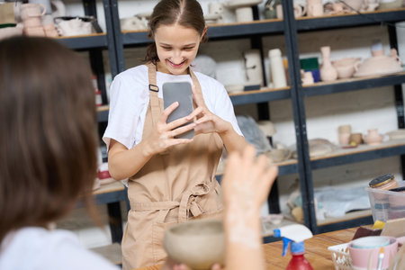 Woman filming her friend with pot in her hands on cameraの写真素材
