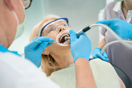 Blonde Caucasian female is getting the cavity of the teeth in medical officeの写真素材