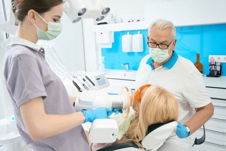 Unrecognized blonde woman is receiving dental treatment in stomatology clinicの写真素材