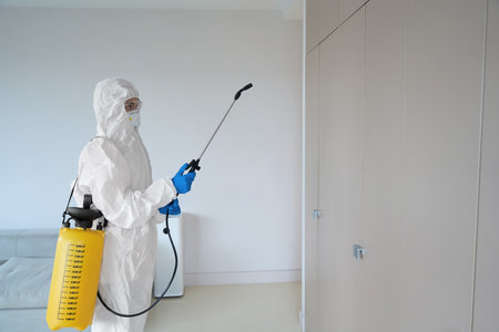 Sanitizer in protective clothes and glasses with sprayerの写真素材