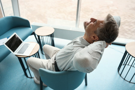 Employee is relaxing in a coworking area with upholstered furnitureの写真素材