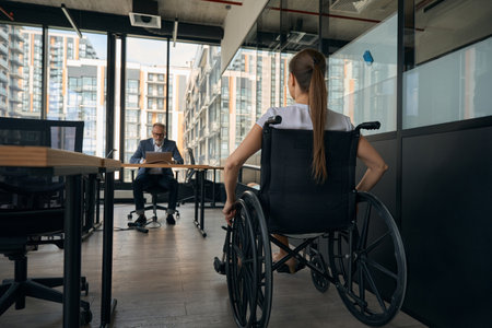 Woman in wheelchair applying for job in officeの写真素材