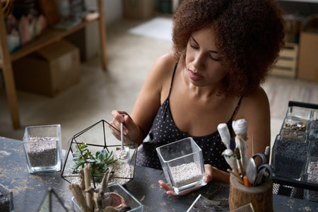 Focused young lady making a nice florarium in her workshopの写真素材