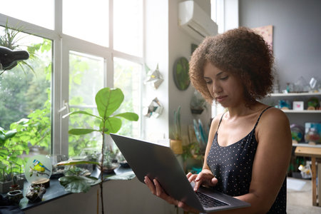 Attractive female florist accepting orders online from home