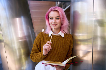 Female standing in the room and making notes to diaryの写真素材