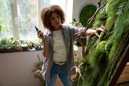 Young woman making picture of green plants in workshop