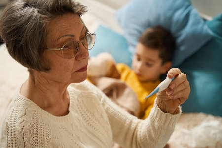 Old lady looking at temperature measurement of boy