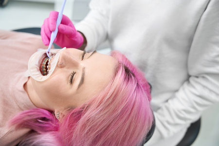 Female patient with dental retainer examines orthodontist