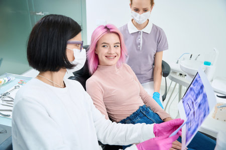Cheerful young woman at the reception at the orthodontistの写真素材
