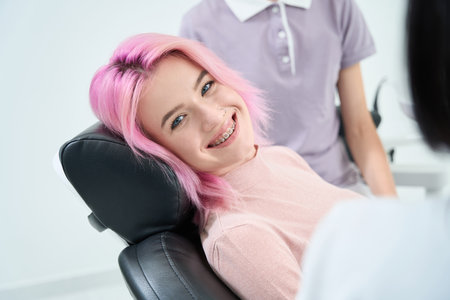 Patient with braces sits in a dental chairの写真素材