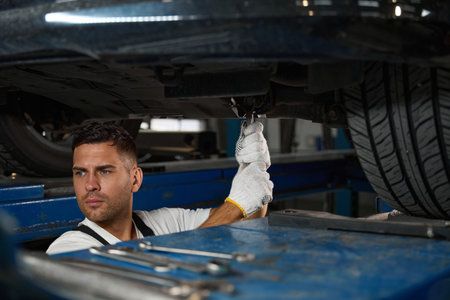 Portrait of man checking technical condition of car wheel