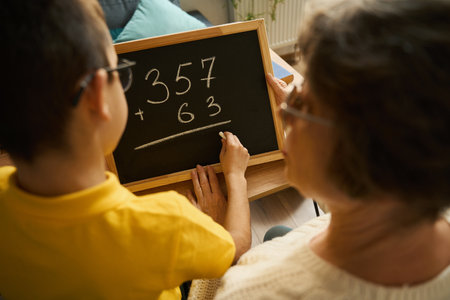 Grandmother helping grandson study math at home
