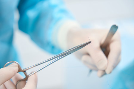 Well-trained surgeon operating medical suturing tools with care and precisionの写真素材