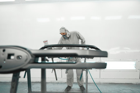 Male in respirator doing color restoration for car partsの写真素材