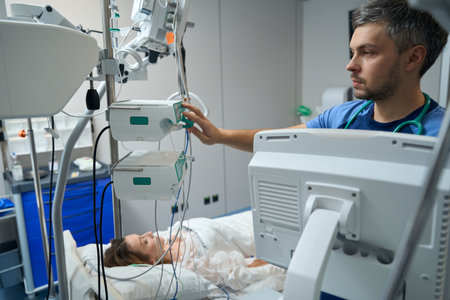 Nurse examining a patient in intensive care