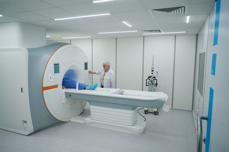 Elderly diagnostician examines a patient on an MRI machineの写真素材
