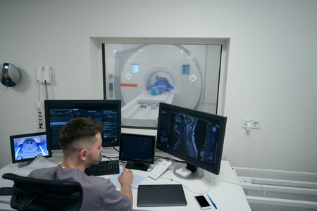 Young doctor conducts MRI diagnostics in a modern clinic