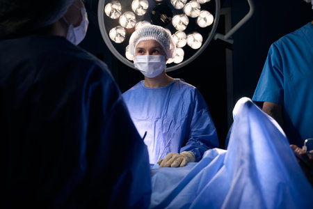 Woman surgeon stands in the operating room at surgical table
