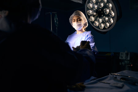 Woman in a surgical uniform stands at the operating tableの写真素材