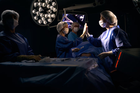 Surgeon and the assistant give high five after successful operationの写真素材