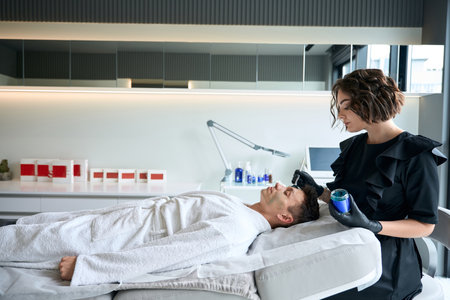 Dermatologist apply revitalizing mask for face to manの写真素材