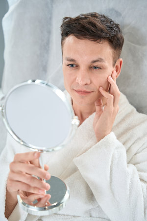 Man looking in mirror in the beauty salonの写真素材