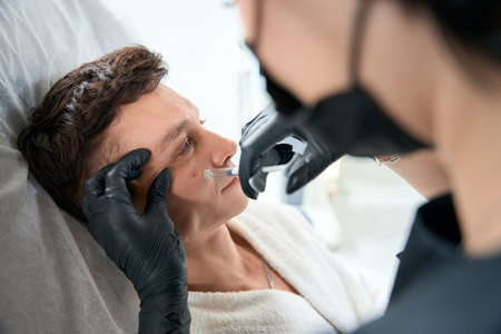 Handsome man getting face anti age injectionの写真素材