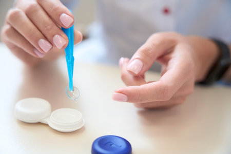 Close up of unrecognized person is holding transparent disposable lensesの写真素材