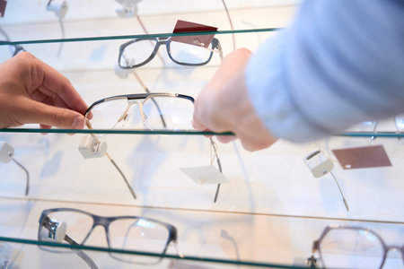 Man hands is holding luxury optician frame in the storeの写真素材
