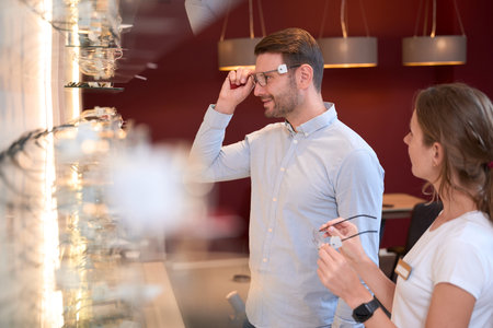 Bearded Caucasian male is enjoying the choosing glasses in the optical storeの写真素材
