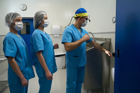 Surgeon and his assistants do sanitization of hands before operationの写真素材