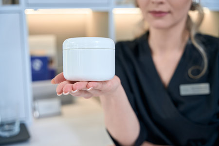 Close up photo of dermatologist showing product to cameraの写真素材