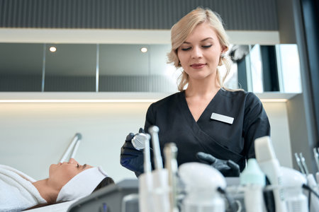 Cosmetologist preparing for skin rejuvenation therapy, working in salonの写真素材