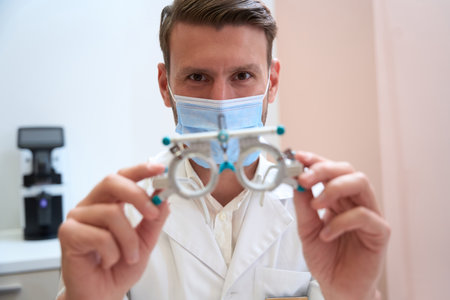 Adorable concentrated man with trial frame in ophthalmology clinicの写真素材