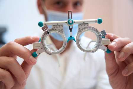 Qualified doctor is showing special ophthalmology equipment in his handの写真素材