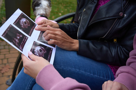 Woman showing ultrasound images to her partner outdoorsの写真素材