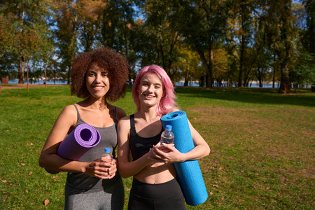 Cheerful sporty ladies posing for camera after outdoor workoutの写真素材