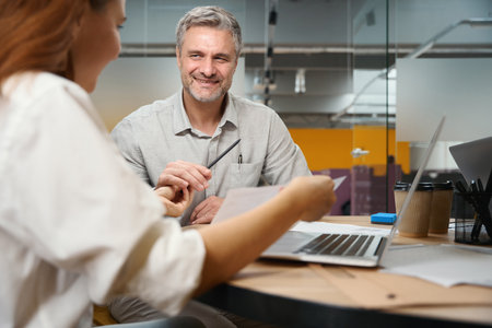Young lady talking with man in the officeの写真素材