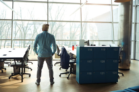Male standing in coworking and looking in the windowの写真素材