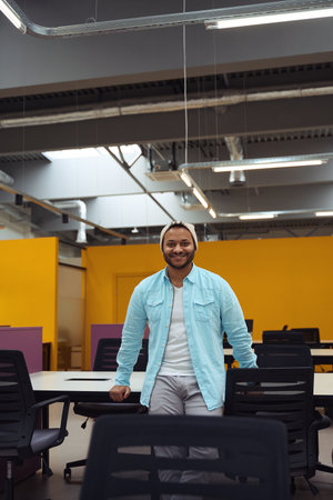 Smiling man standing near table in the business centerの写真素材